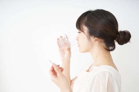 Young woman taking oral medicineの写真素材