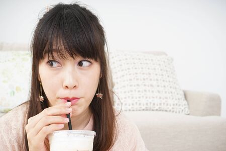 Young woman drinking coffee at roomの写真素材