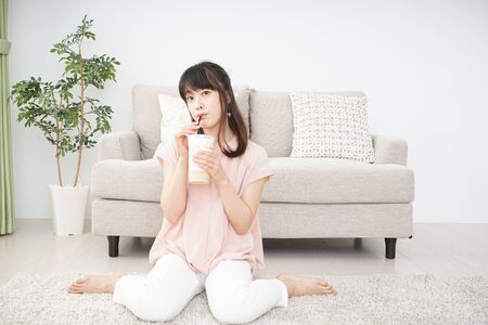 Young woman drinking coffee at roomの写真素材