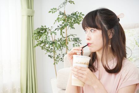Young woman drinking coffee at roomの写真素材
