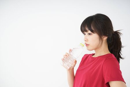 Young woman staying hydrated during sportの写真素材
