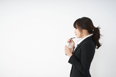 Young businesswoman drinking ice coffee at officeの写真素材