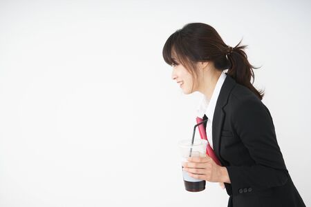 Young businesswoman drinking ice coffee at officeの写真素材