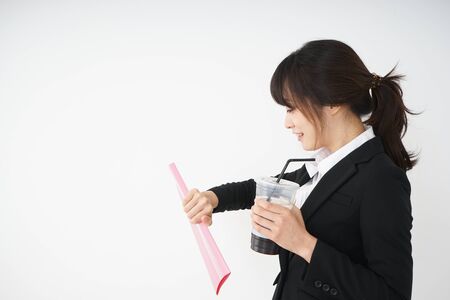 Young businesswoman drinking ice coffee at officeの写真素材