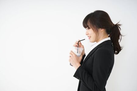 Young businesswoman drinking ice coffee at officeの写真素材