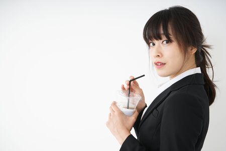 Young businesswoman drinking ice coffee at officeの写真素材