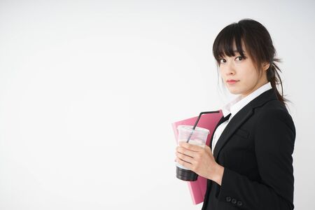 Young businesswoman drinking ice coffee at officeの写真素材