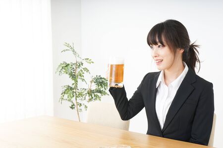 Businesswoman in suit cracking a beerの写真素材