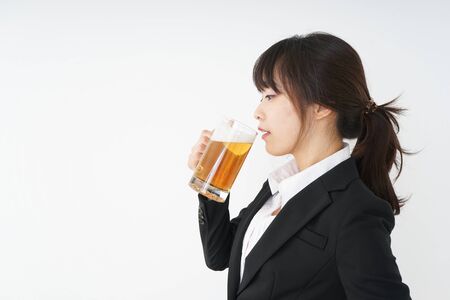 Businesswoman in suit cracking a beerの写真素材