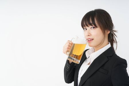 Businesswoman in suit cracking a beerの写真素材