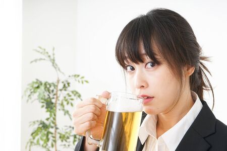 Businesswoman in suit cracking a beerの写真素材