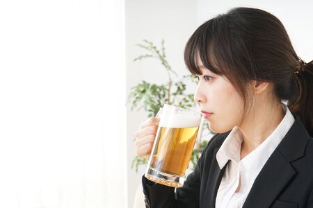 Businesswoman in suit cracking a beerの写真素材