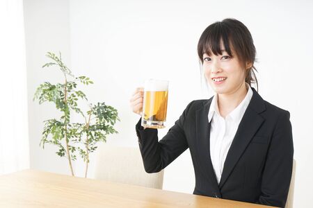 Businesswoman in suit cracking a beerの写真素材