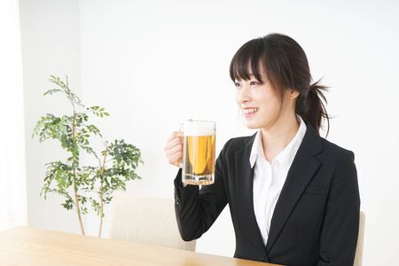 Businesswoman in suit cracking a beerの写真素材