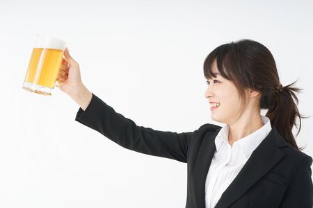 Businesswoman in suit cracking a beerの写真素材