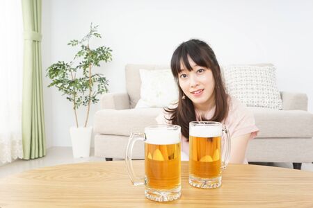 Young woman drinking beerの写真素材