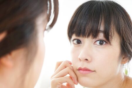 Young woman caring for skin problemsの写真素材