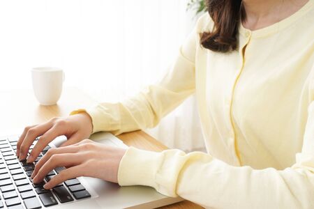 Young woman typing with laptopの写真素材