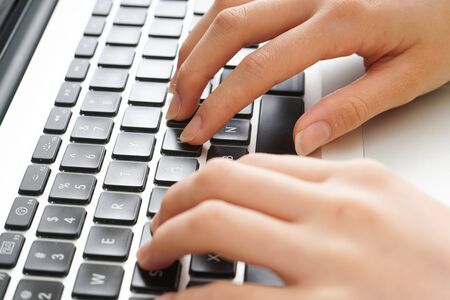 Young woman typing with laptopの写真素材