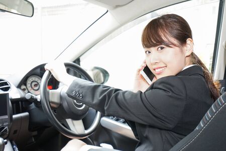 Career woman telephoning in carの写真素材