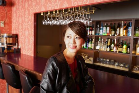 Woman sitting on bar counterの写真素材