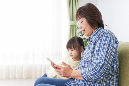Child using smartphone with grandmother