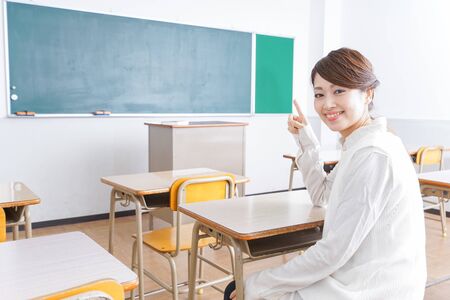 Student pointing to something in classroomの写真素材