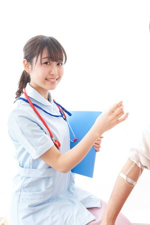 Nurse putting woman on a dripの写真素材