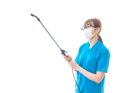 Nurse wearing mask and holding a spray gun to clean the air