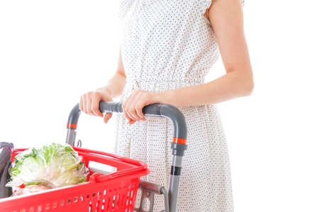 Woman with a shopping cart full of groceries isolated on a white backgroundの写真素材