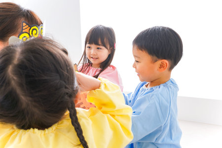 Children playing with teacher at kindergarten, high angle view. Happy family.