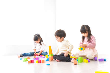 Children playing with building blocks in the white room, high quality photoの写真素材