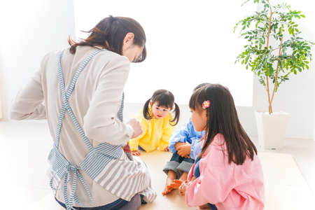 Mother and children playing in the living room at home high quality photoの写真素材