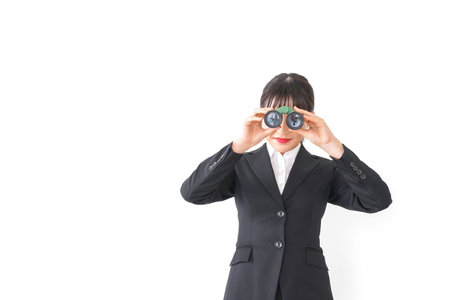 Businesswoman looking through binoculars taken in the studio with white background