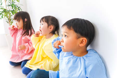 Children brushing their teeth indoors, shot from the side, high quality photoの写真素材