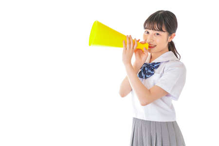 A high school girl holding a megaphone shot in the studioの写真素材