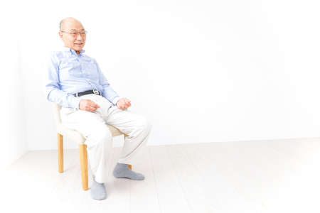 Aged man sitting on the chairの写真素材