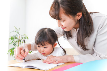 Mother and daughter writing in a notebook at the table high quality photo