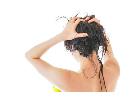 Young woman with wet hair on white background, closeup. Haircare concept