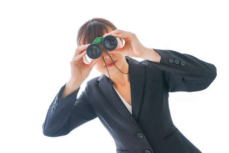 Businesswoman watching through binoculars shot in the studio on white backgroundの写真素材
