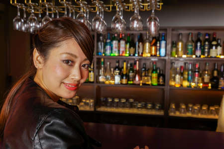 Woman sitting on bar counterの写真素材
