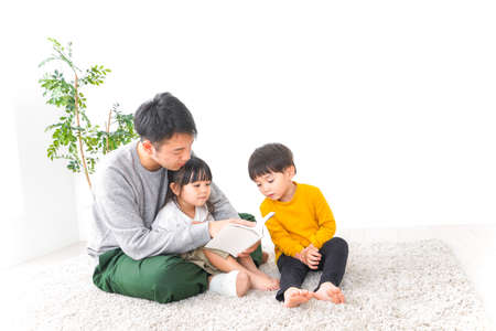 Asian family sitting on the floor in the living room at home.の写真素材