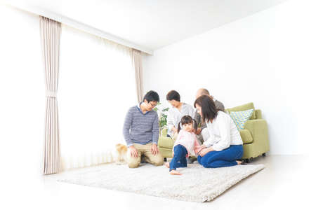 Three-generation family taking care of dogの写真素材