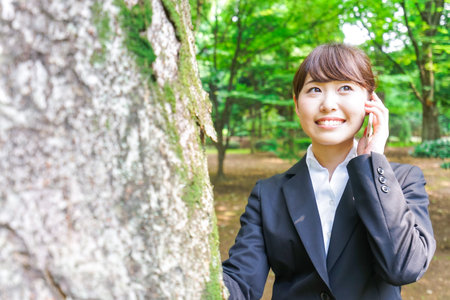 Business woman calling outsideの写真素材