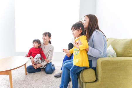 Mother and children watching TV in the living room at home, high quality photo