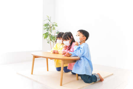 Children playing at home with face mask, Covid-19 conceptの写真素材