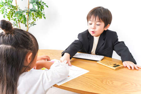 Child and teacher at the desk in the class roomの写真素材