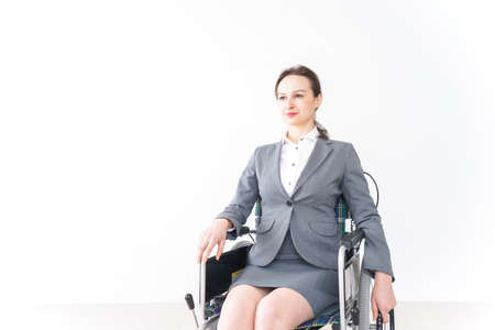 Disabled business woman in a wheelchair, image taken in the studio.の写真素材