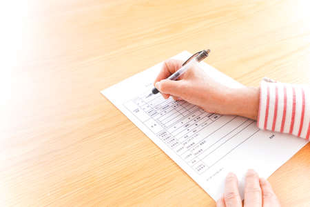 Close-up Of A Person's Hand Writing On A Paper With Penの写真素材