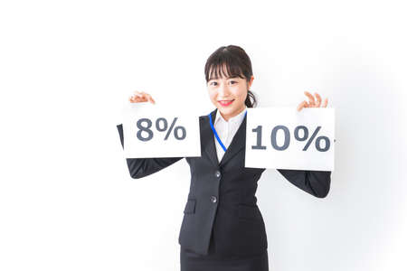 A business woman in a suit holding a percentage sign taken in the studioの写真素材